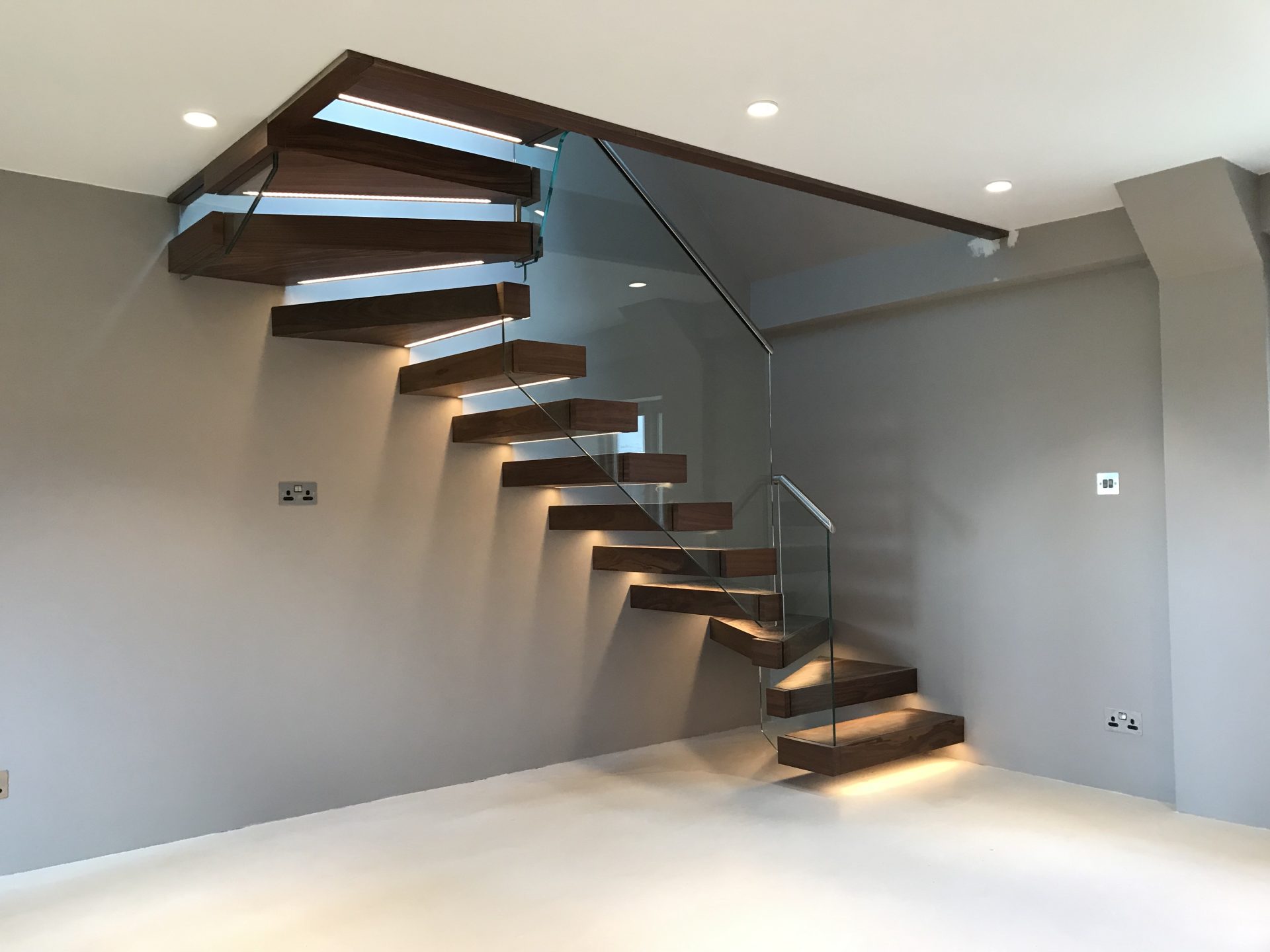 A walnut floating staircase with LED lighting.